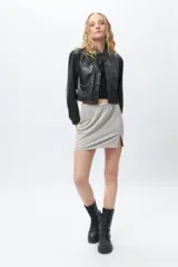 Minifalda gris con fibras metálicas, elastizada, con elástico en la cintura y abertura lateral.