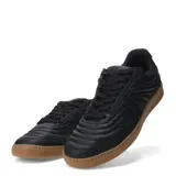 Championes urbanos negros de caña baja con capellada acolchada con patrón de ondas y suela de goma color caramelo.