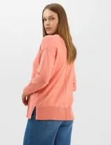Buzo de tejido fino color amarillo, con cuello redondo, manga larga con puños acanalados y pespunte central vertical en el frente y la espalda. Presenta un ruedo ancho acanalado con tajos laterales.
