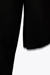 Jersey de punto de manga larga con cuello redondo y diseño de corte clásico. Presenta terminaciones en rib y aberturas laterales en el bajo.
