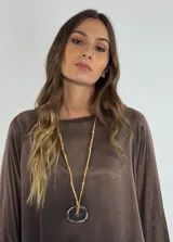 Collar dorado con cadena de eslabones y dije circular de piedra natural con borde irregular.