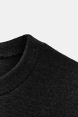 Top de cuello redondo y manga corta, confeccionado en tejido suave con costura central vertical y cintura entallada.