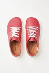 Zapatillas de cuero blanco con diseño minimalista, cordones al tono y suela de goma color suela con costura vista.