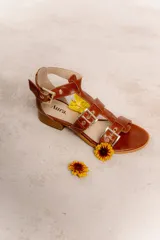 Sandalia de cuero vacuno color negro, con múltiples tiras y hebillas metálicas ajustables. Tiene taco bajo, forro y plantilla de cuero, y suela sintética.