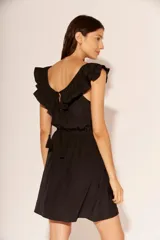 Vestido corto de color negro, con escote redondo adornado con volados y cintura elástica.