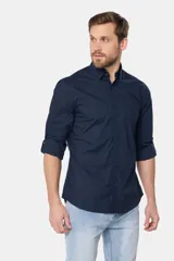 Camisa lisa de manga larga de algodón en color gris claro, de corte slim fit con cuello camisero y cierre frontal de botones.