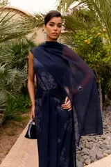 Vestido largo azul marino sin mangas, con cuello drapeado y un lazo frontal cruzado en la cintura. Cuenta con un sutil estampado floral tonal.