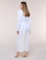 Sobrecamisa beige de lino liviano, con cuello camisero, cierre frontal de botones carey y bolsillos en el pecho. Cuenta con cordón ajustable en la cintura y mangas largas.