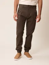 Pantalón bombacha de sarga marrón oscuro, con pinzas en la cintura, bolsillos laterales y terminación con puño elástico en los tobillos.
