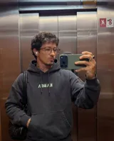 Canguro negro de corte oversize, con capucha ajustable mediante cordones y bolsillo frontal tipo canguro. Presenta un estampado frontal con la palabra 'KABOA' en tipografía gótica de color verde claro.
