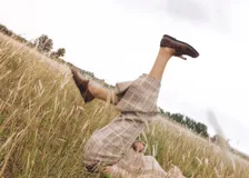 Pantalón de lana a cuadros color beige y blanco, entallado hasta la rodilla y con caída amplia tipo oxford, tajos laterales, elástico en la cintura y cierre oculto.