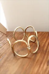 Pulsera rígida dorada con diseño de eslabones ovalados.