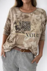 Remera de la línea italiana, color blanco con estampado frontal de animal print en tonos dorados y negros, y la frase "Find your true NATURE". Tiene cuello redondo, mangas largas y cordón regulable en la parte inferior para ajustar el largo.