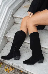 Bota texana de caña alta color negro, confeccionada en cuero gamuzado, con puntera fina y taco bajo.