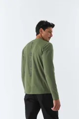 Remera verde militar de manga larga, cuello redondo y corte recto. Estampa pequeña en el pecho con texto en negro.