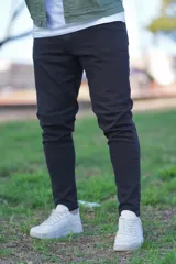 Pantalón skinny negro, de corte ajustado en las piernas y tiro medio.