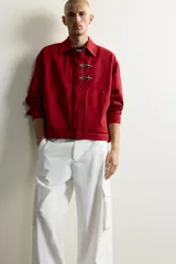 Cazadora relaxed fit de Zara confeccionada en tejido de algodón rojo con efecto lavado. Presenta cuello solapa, manga larga, bolsillos de plastrón en la cadera y cierre frontal de cremallera oculta con solapa y alamares metálicos.