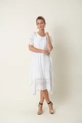Vestido blanco de seda con mangas cortas y bajo con detalles de broderie.