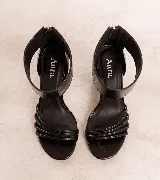 Sandalias de tacón alto en color negro, confeccionadas en 100% cuero vacuno. Presentan un diseño elegante con tiras finas en la parte delantera y una pulsera ancha en el tobillo con cierre de cremallera en la parte trasera. Cuenta con un taco ancho.