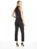 Pantalón de crepe marca Zac & Rachel, color negro, de corte recto y entallado, con largo hasta el tobillo. Presenta pretina con detalles en cuero sintético, pasadores funcionales, cierre con broche interno y bolsillos aplicados en la parte delantera.