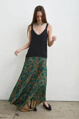 Musculosa de seda color negro, con escote en V y tirantes anchos, de corte fluido y suelto.