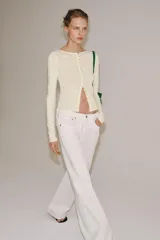 Camiseta slim fit de algodón color crudo, con cuello redondo, manga larga y cierre frontal de múltiples botones pequeños.