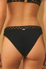 Conjunto de bikini color verde azulado con diseño de cortes láser decorativos en los bordes del corpiño y la bombacha. El corpiño es de estilo triangular con tirantes anchos y la bombacha es de corte clásico.