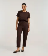 Blusa fucsia de manga corta con cuello redondo pespunteado, diseño sin estampa y efecto airflow con textura sutil. Cuenta con abertura trasera tipo gota y cierre con botón.
