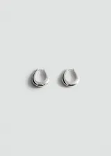 Aros tipo argolla de diseño minimalista y forma orgánica, con acabado metálico plateado.
