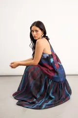 Vestido largo sin mangas, con escote halter y abertura en el pecho, corte holgado y diseño combinado de estampa abstracta floral en la parte superior y rayas verticales traslúcidas en la falda.