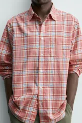 Camisa de manga larga relaxed fit a cuadros en tonos rosados, rojos y celestes. Cuenta con cuello abotonado, bolsillo de parche en el pecho y cierre frontal con botones.