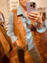 Chaleco de cuero vacuno color marrón claro con flecos largos en el frente.