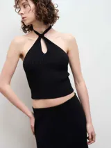 Top de punto acanalado color negro, con diseño de cuello halter y abertura frontal tipo gota.