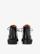 Borcegos de caña media de cuero semibrillante negro, con cordones de algodón y suela gruesa de EVA porosa con plataforma baja.