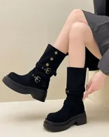 Botas de media caña negras de gamuza con suela track y hebillas decorativas.