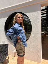 Short de denim con efecto acid wash y lavado envejecido en tonos marrones y negros, tiro alto y dobladillo desmechado.