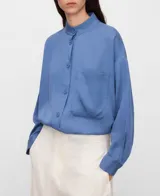Camisa de lyocell color azul con cuello mao, botonadura frontal, manga larga con puño abotonado y un bolsillo en el pecho.