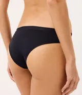 Kit de tres bombachas modelo bikini de la marca Lov, confeccionadas en microfibra lisa con cintura media y laterales medianos. Incluye una pieza en color blanco, otra en color beige y otra en color negro.