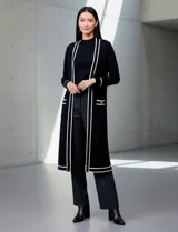 Cardigan largo de punto marca Via Milano, color negro con detalles de rayas blancas en contraste. Presenta un diseño abierto sin botones, bolsillos frontales aplicados y ribetes blancos en la apertura, puños y bolsillos.