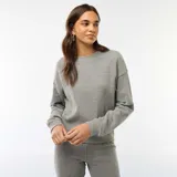 Buzo de punto de textura suave y gruesa, color gris, con cuello redondo y mangas largas con puños elásticos.