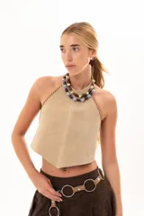 Top de gamuza color visón con escote halter y costuras decorativas con detalle de tientos de cuero en los bordes laterales.