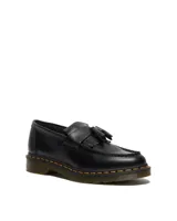 Mocasines Dr. Martens modelo Adrian YS en cuero negro, con diseño de flecos y borlas en el empeine. Presentan la característica costura amarilla en la suela y suela de goma con plataforma.