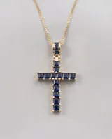 Collar de bronce con baño de oro y dije en forma de cruz decorado con piedras naturales de color azul zafiro.
