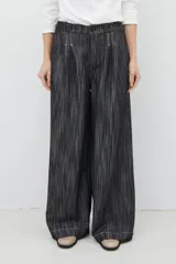 Pantalón de jean azul oscuro de tiro alto, con diseño holgado de pierna ancha, pinzas en la cintura y costuras a la vista.