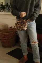 Mini bag tipo limosnera con estampado animal print de leopardo y asa corta.