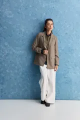 Blazer de corte recto y silueta relajada, de color tostado, con solapas clásicas y bolsillos con solapa en los laterales.