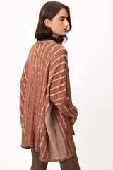 Sweater de tejido artesanal con diseño de rayas verticales en tonos camel y beige, corte holgado, cuello redondo y puños altos ajustados.
