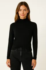 Polera de tejido acanalado color beige, con cuello alto y detalle de botones decorativos en el hombro. De corte ajustado al cuerpo y manga larga.