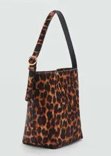Bolso tipo shopper de tamaño mediano, confeccionado en piel bovina con pelo y estampado de leopardo. Cuenta con asa de hombro ajustable, cierre principal de cremallera y cierre de imán interior.