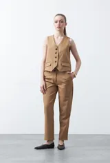 Chaleco sastrero color marrón oscuro, con escote en V, cierre frontal de botones y pinzas de entalle.